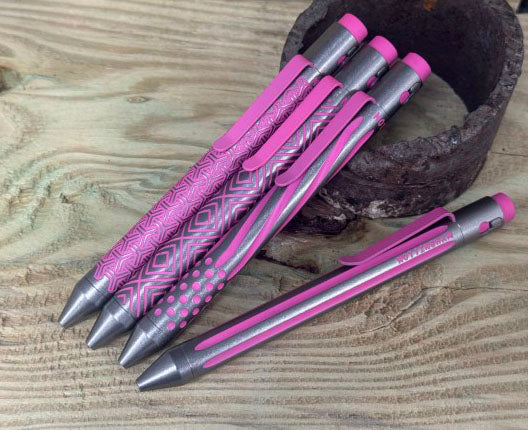 Titanium Custom Cerakote Pens in pink and gray displayed on wooden surface - NTI tactical pens